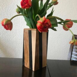 Handgemaakte houten vaas met rode bloemen